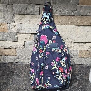 Vera Bradley sling backpack in a navy blue floral pattern.